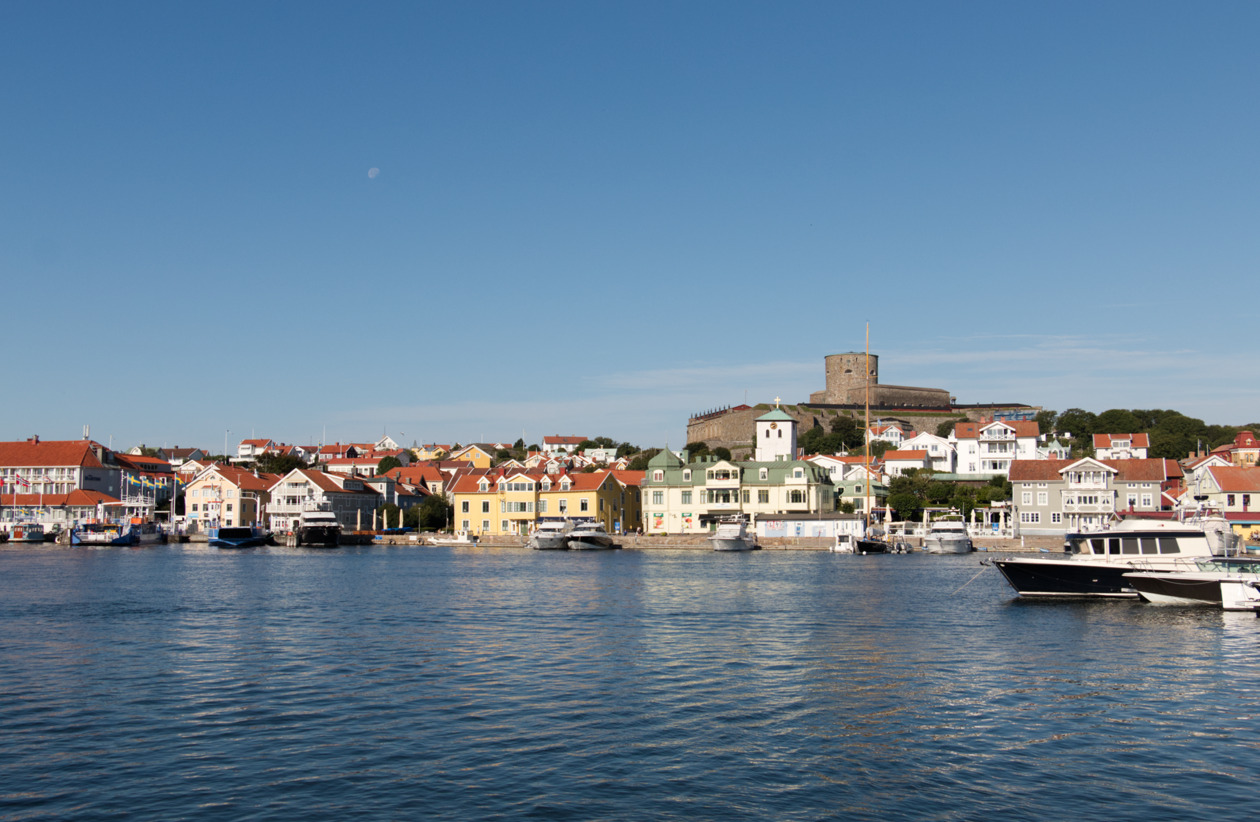 Stor vy rakt på Marstrand med Carlstens fästing högst upp och havet i förgrunden. 