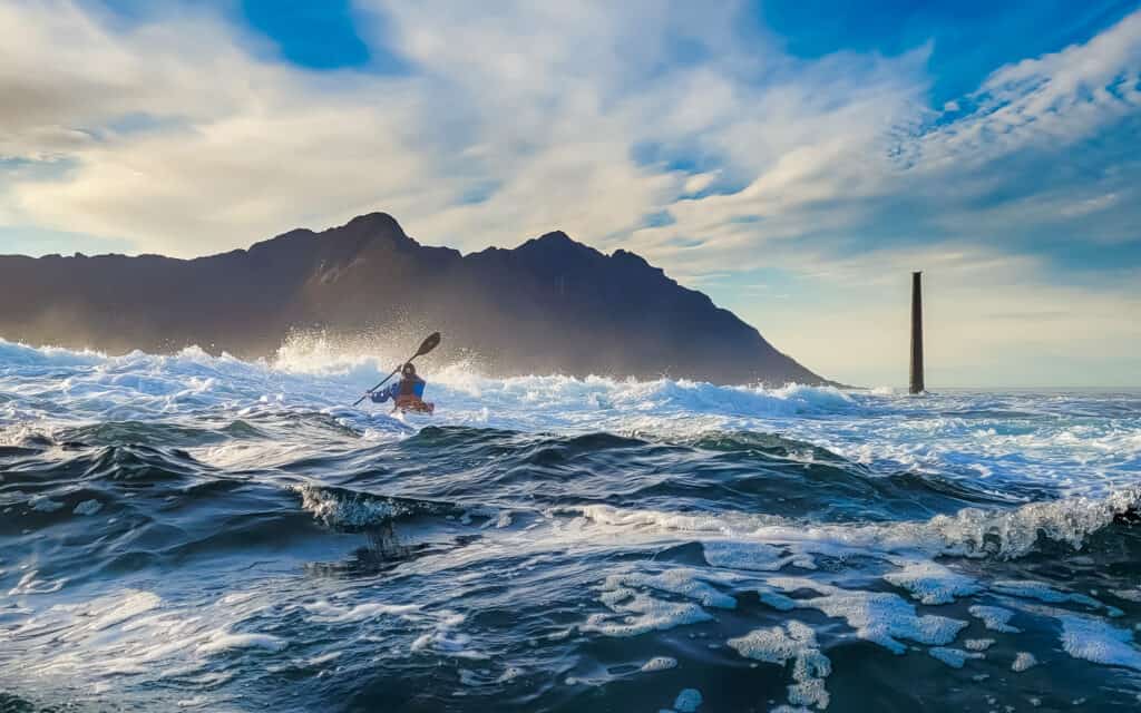 kayaker surfing in Senja in Norway during teknikkurs havkajakk