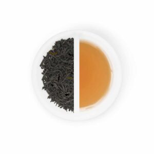 displays dried black Lapsang souchong leaves with the deep golden tea it produces