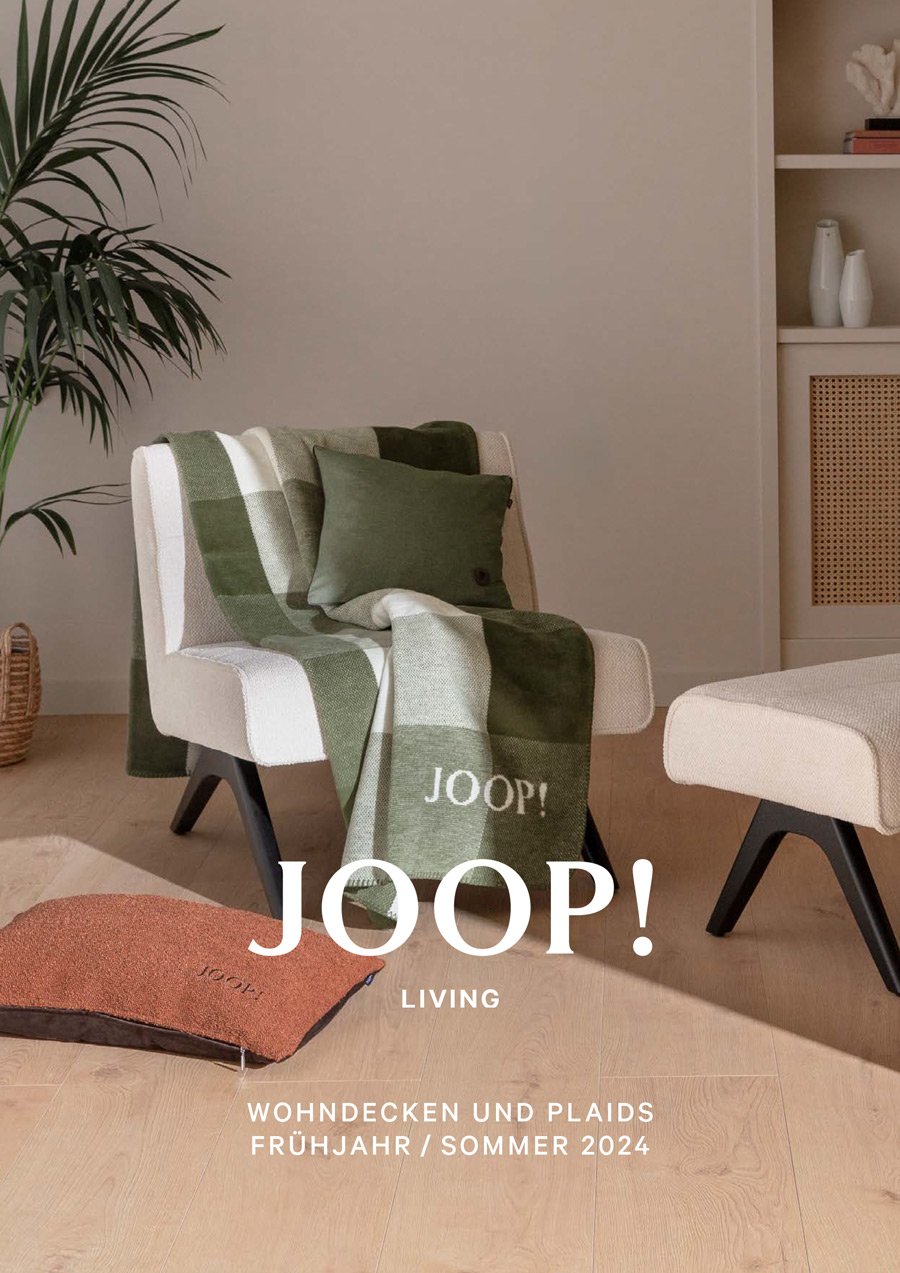 En JOOP filt liggande på en fåtölj i rutor gråa nyanser ett lyx märke