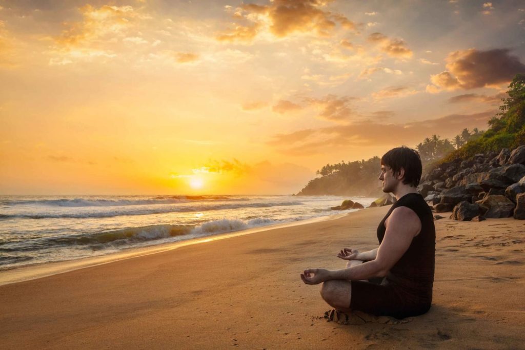 A traveler deep in thought or meditation in a remote setting