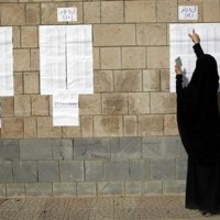 Woman checks her name before she votes at a polling station during presidential elections in Al Hasaba neighborhood in Sanaa