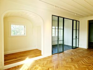 Sekelskiftesdetaljer med valv, glaspartier och fiskbensparkett i Villa Tallbo på Lidingö