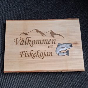Träskylt "välkommen till fiskekojan" med lax