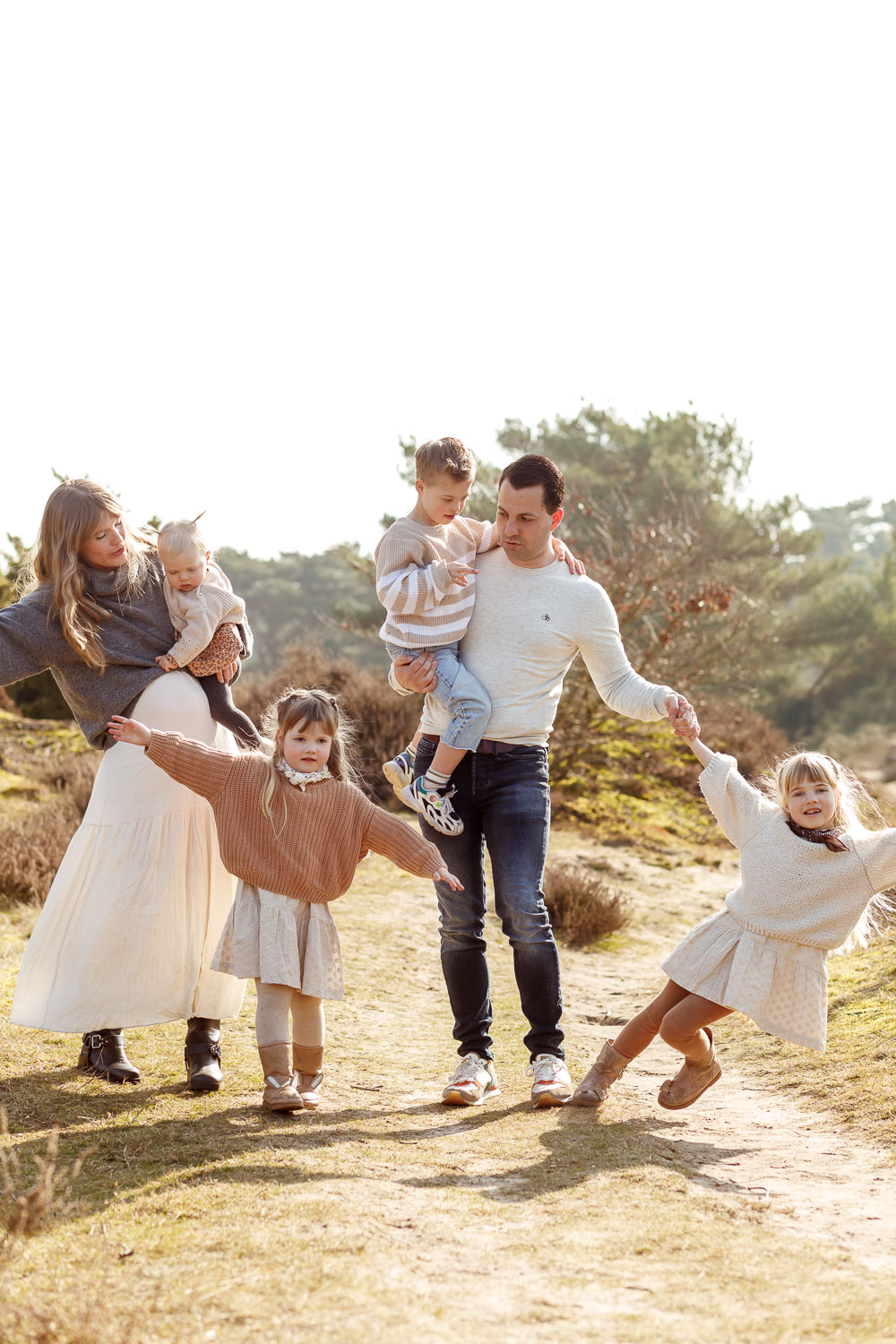 Gezinsfotograaf Groningen – Spontane familieshoot in de Zeegse Duinen met ouders en vier kinderen, vastgelegd in warm, natuurlijk licht.