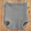OPSKRIFT Model Trunte Baby Strikkede Bloomers: Cremefarvede, teksturerede strikkede babybloomers med benåbninger.