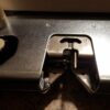 Nærbillede af den elektroniske strikkemaskine Silver Reed SK840, der viser nålene og børstemekanismen. Ideel til strikkeentusiaster.