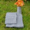 Hand-knitted gray wool shawl, OPSKRIFT - MODEL ANDREA VÆRTINDE GAVE. Soft, textured fabric.
