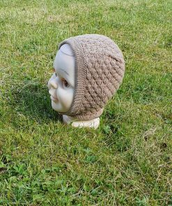 Yndig babyhue i beige, håndstrikket med et struktureret mønster.