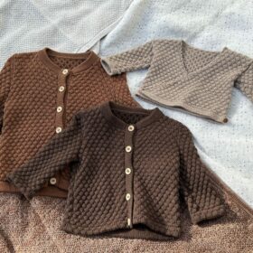 Tre håndstrikkede cardigans i brune og beige nuancer.