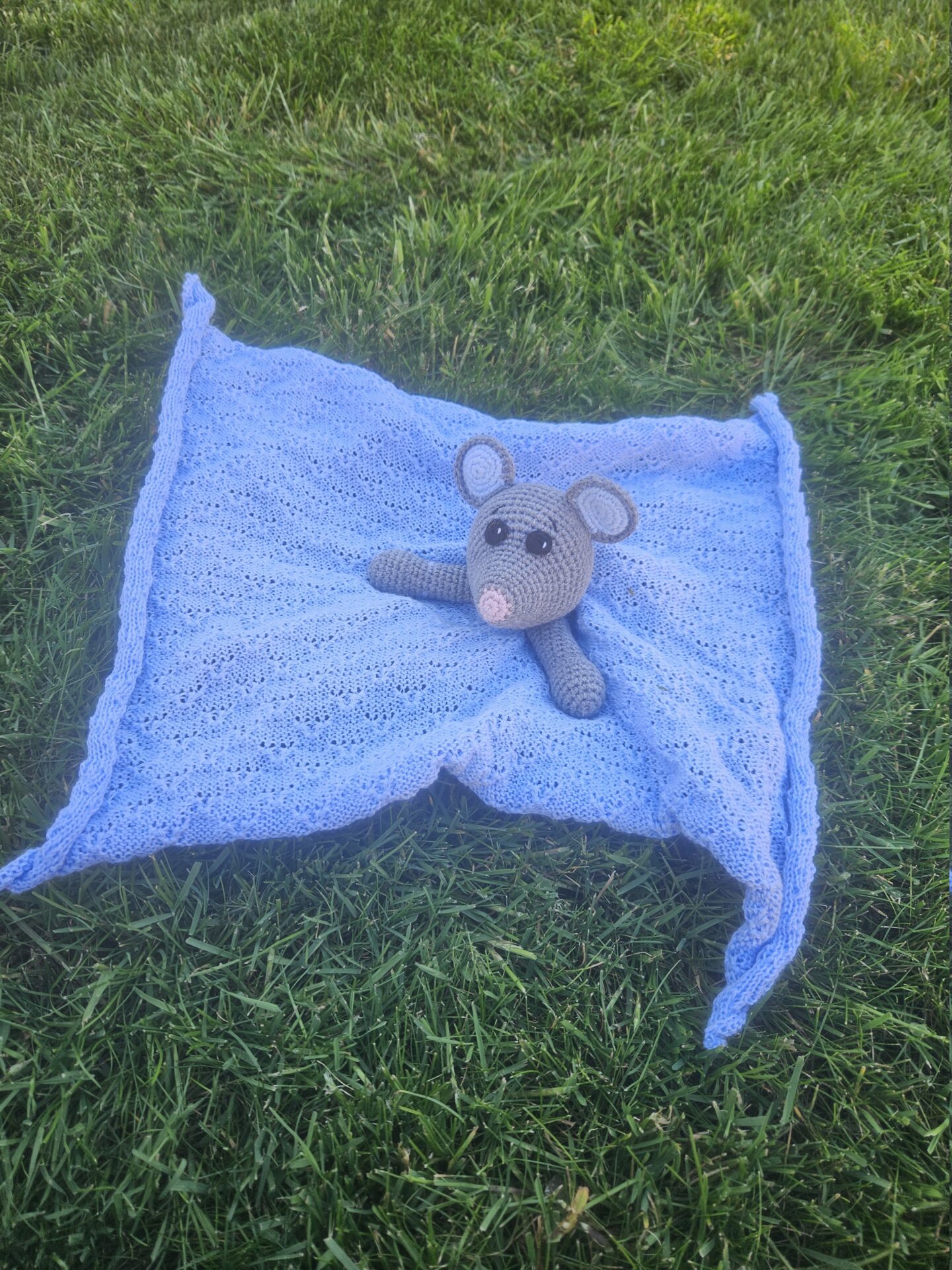 Håndhæklet mus på et lyseblåt babytæppe. Danskproduceret.