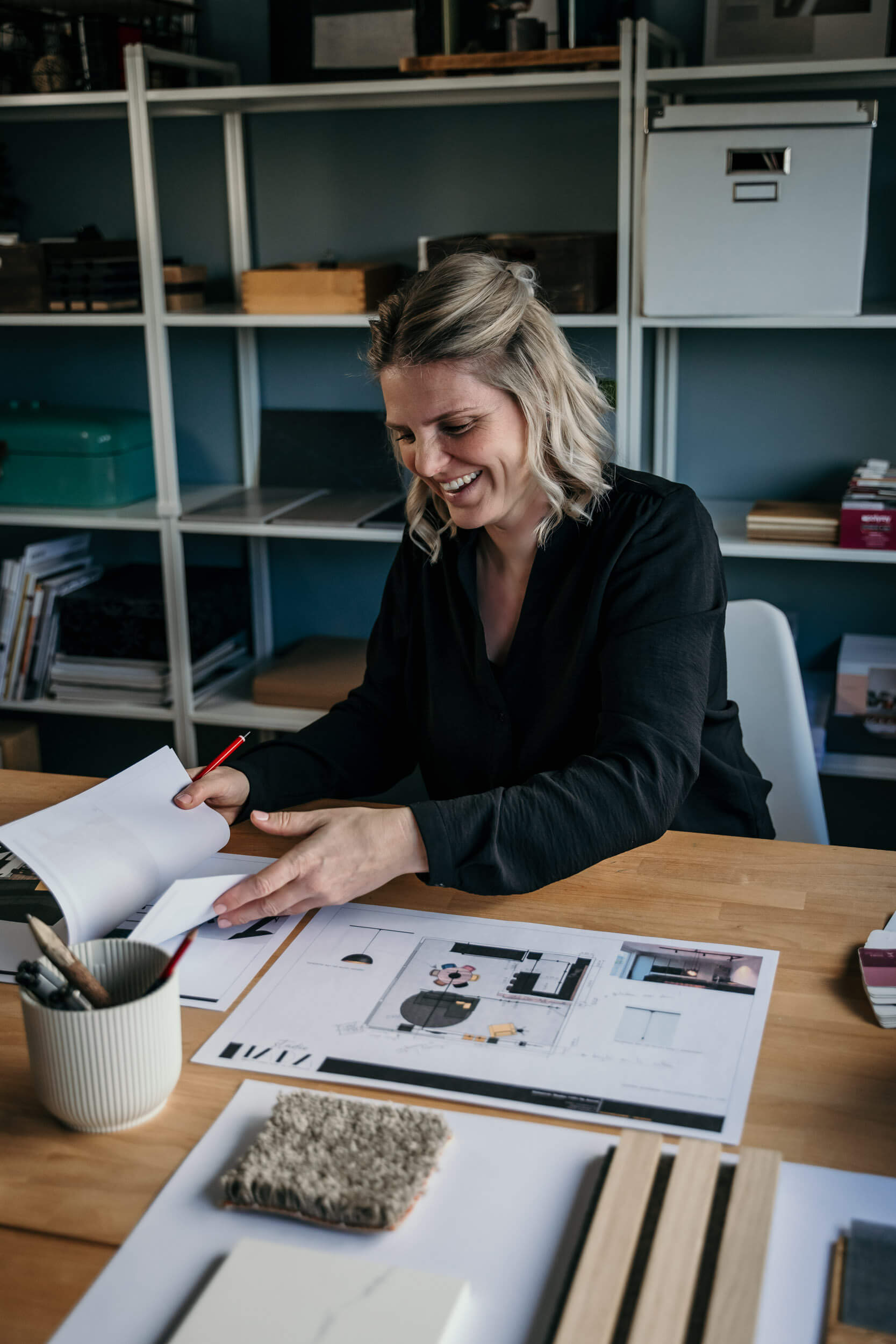 Interieurvormgever Anouk bladert door enkele 2D- en 3D-ontwerpen die ze voor een interieurontwerp gemaakt heeft