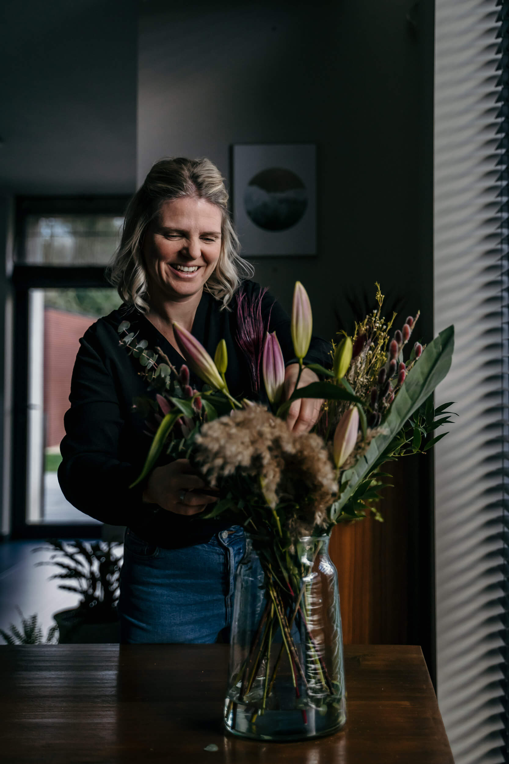 Interieurvormgever zorgt er tijdens een interieurstyling voor dat alles klopt, ook de vaas met bloemen