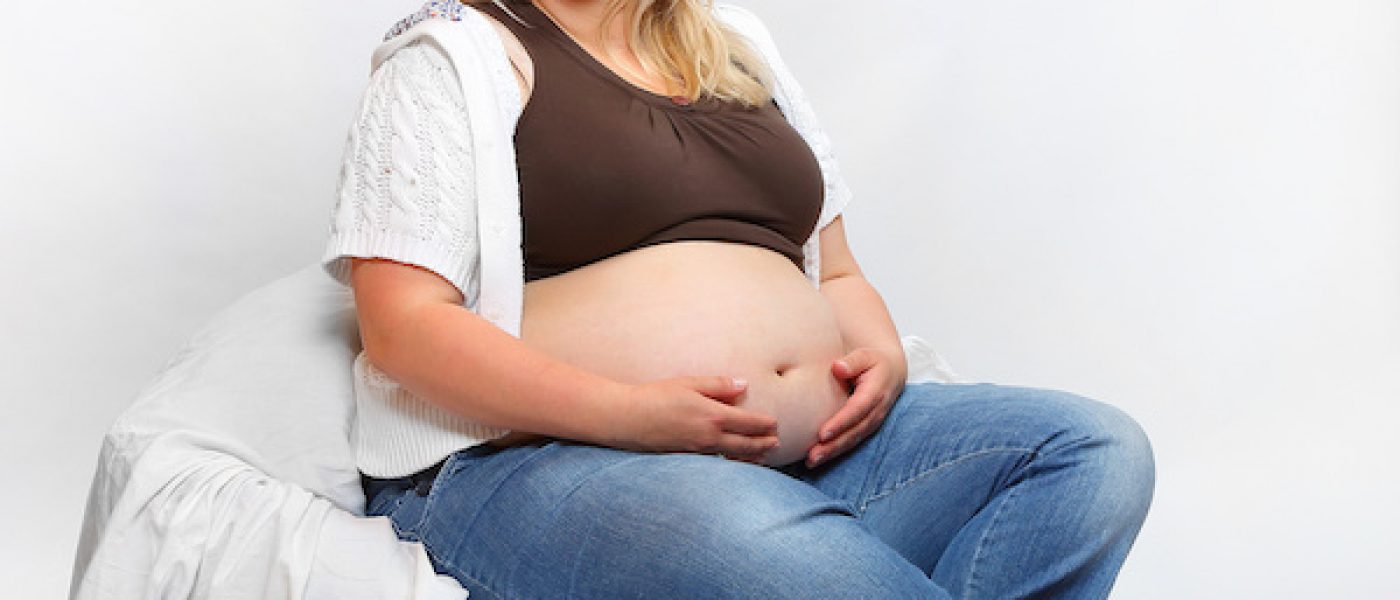 Overweight pregnant woman relaxing in the bedroom. Health and body care concept. Unhealthy lifestyle problems.