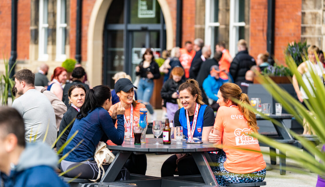 People sitting around an outside table with drinks.