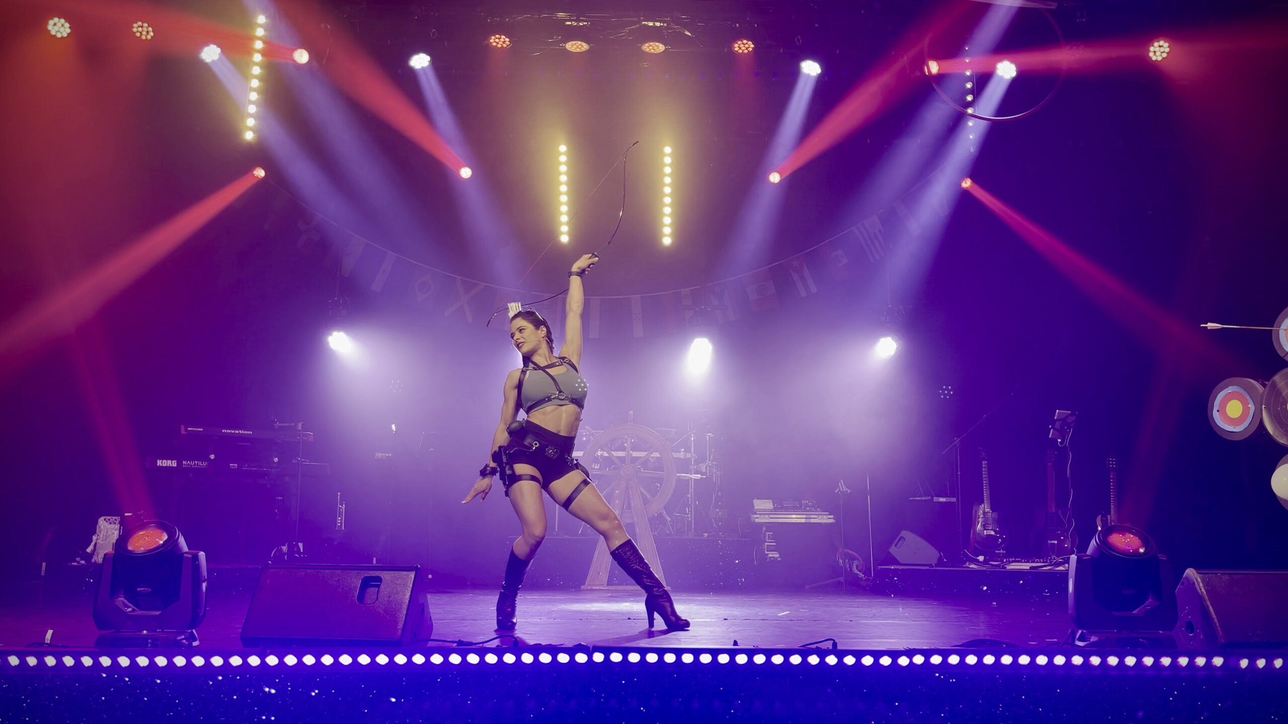 Artistin beim Comedy Bogenschiessen Act auf der Bühne – Bogenschiessen Animation Schweiz buchen
