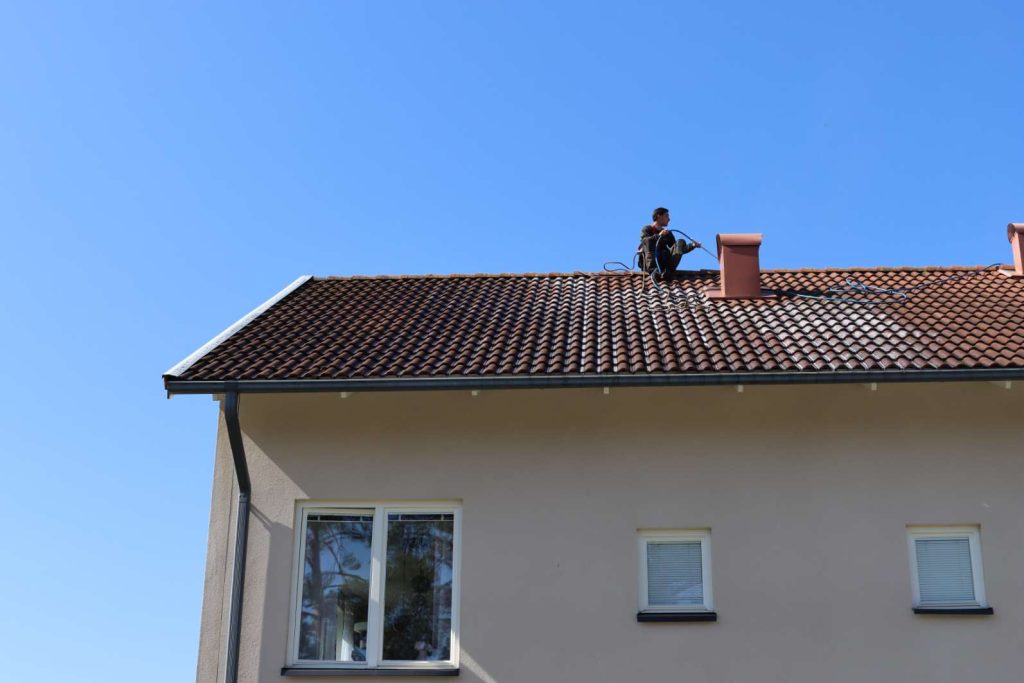 Taktvättad villa i Ekerö med strålande blå himmel i bakgrunden.