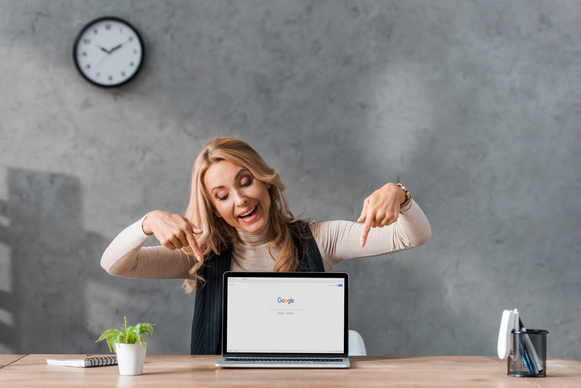 KYIV, UKRAINE - AUGUST 16, 2019: smiling businesswoman pointing with fingers at laptop with google