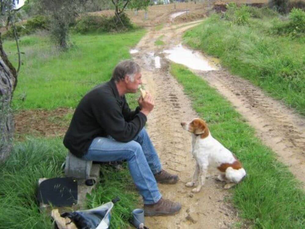 um-homem-e-um-cao-almoçar-durante-um-passeio