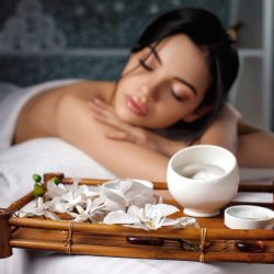 young woman in spa salon. Relaxed beautiful young woman in spa salon. focus on the candle and flower