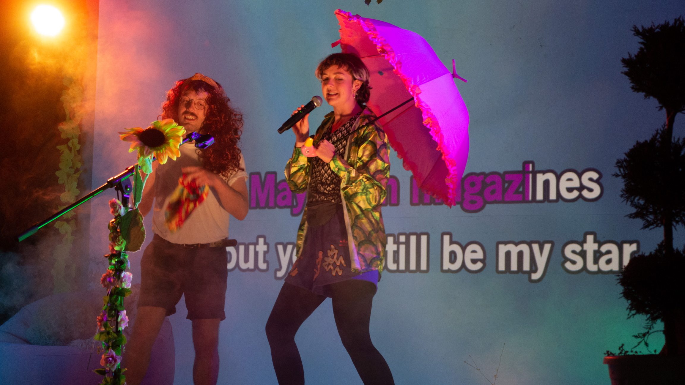 Zwei verkleidete Menschen auf der Bühne beim Karaokesingen