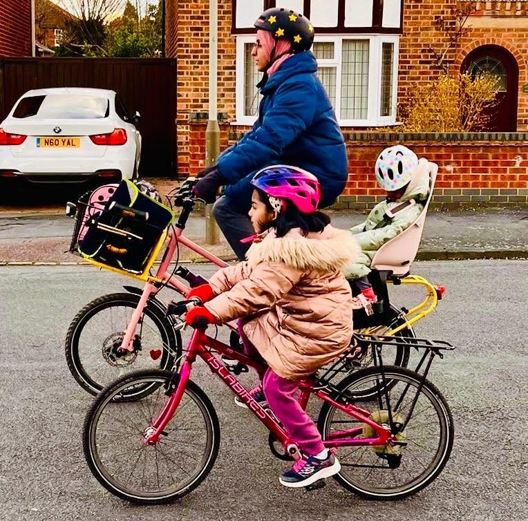 young family on bikes on the way to school