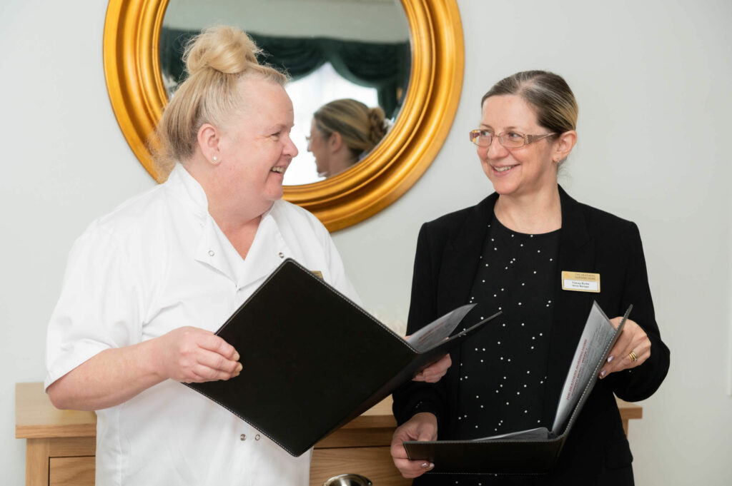 Members of staff smiling whilst going through black books together.