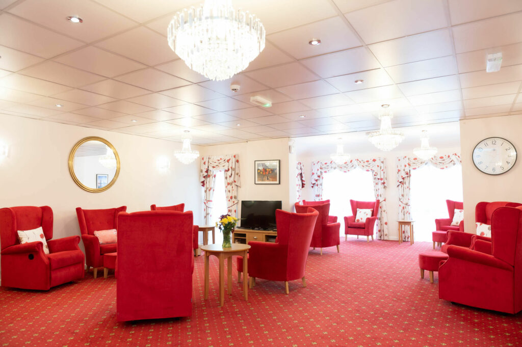 Lounging area with red chairs and carpet.