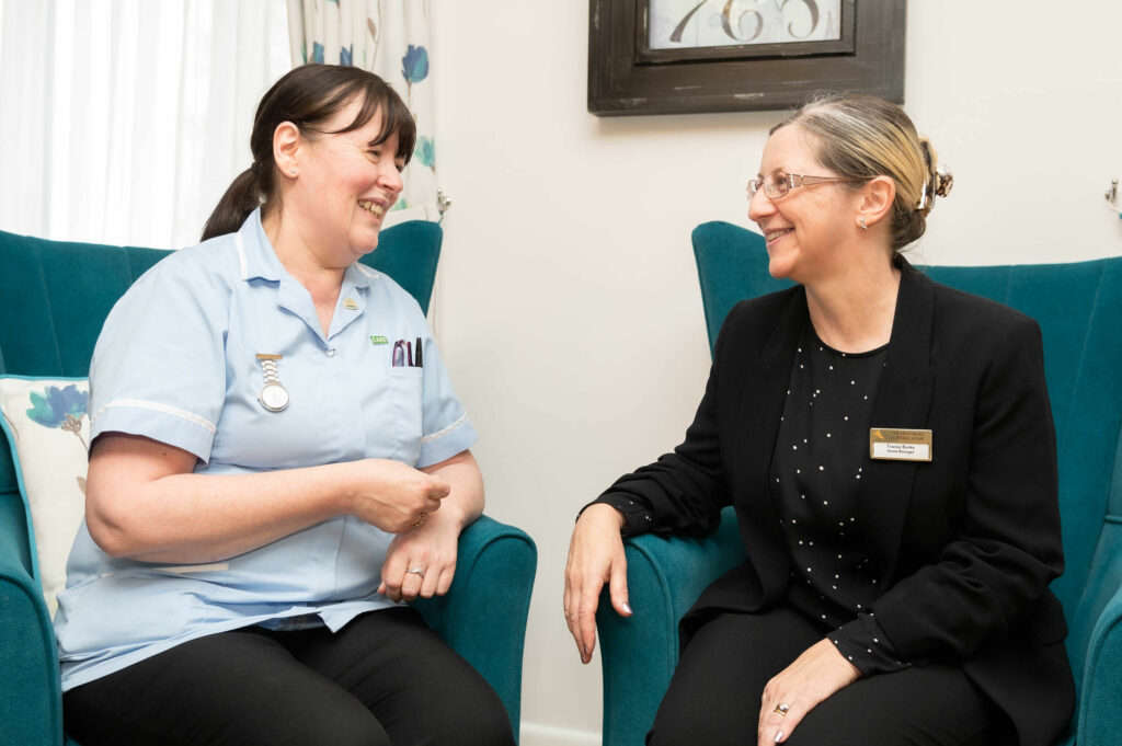 2 members of staff laughing together.