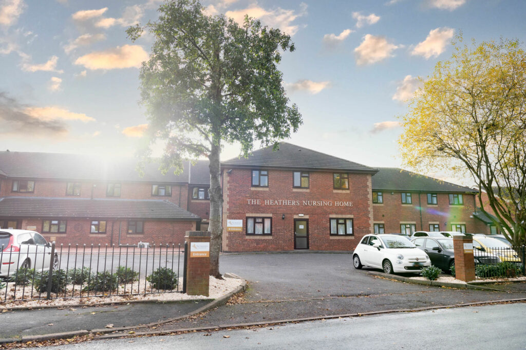 Wide shot of the outside of the building and car park.