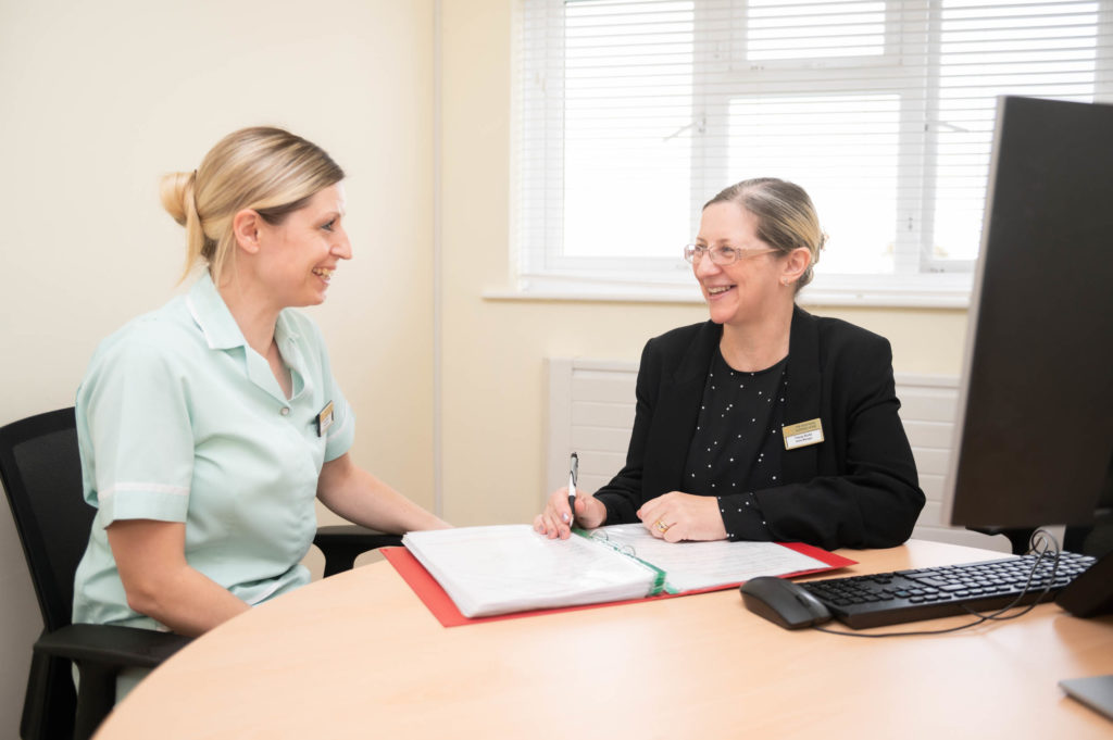 2 members of staff going through a folder together.