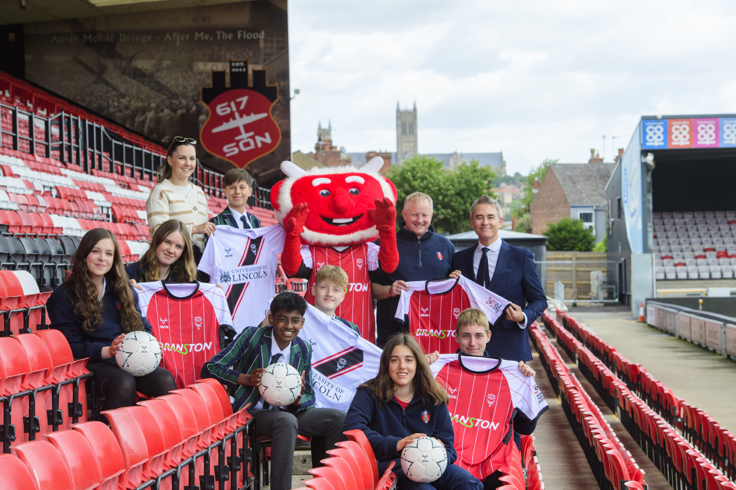 Jason Futers (far right) presents Lincoln City kit and balls to Lincoln Minster's Tom Eves and students who are taking part in the challenge.