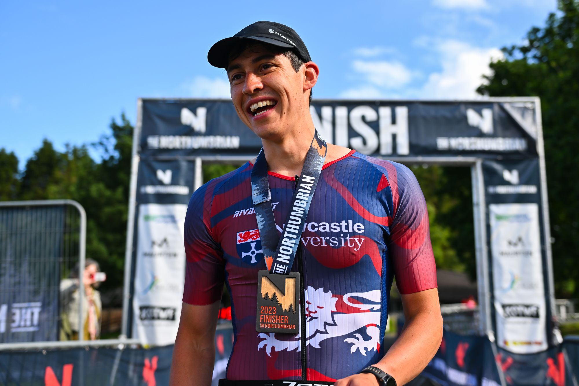 Photo of a man standing in front of a finish gantry.