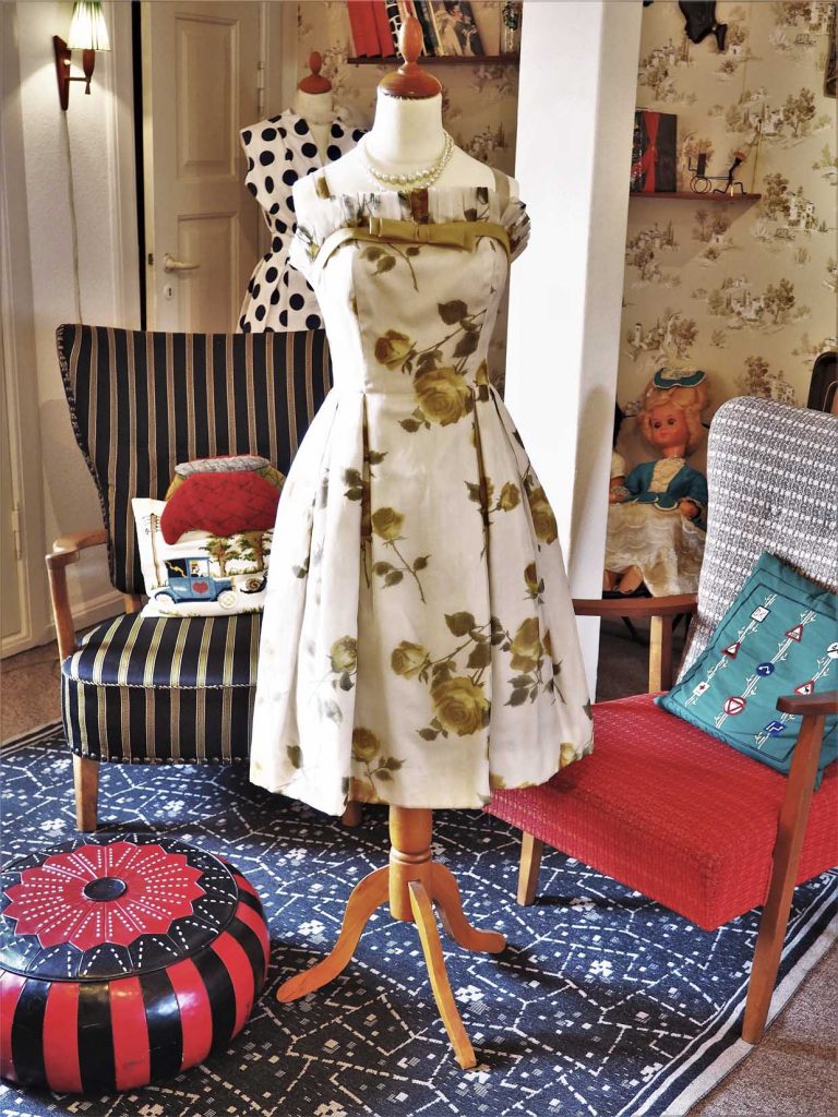 Blomstret kjole fra 1950'erne med smal talje og plisseret skørt, læs om moden i 50'erne, originalt tøj fra 1900-tallet fra museet Tidens Samling, museum for klæder, form og bolig i det 20. århundrede, Kulturmaskinen, Farvergården, Brandts Klædefabrik, Odense