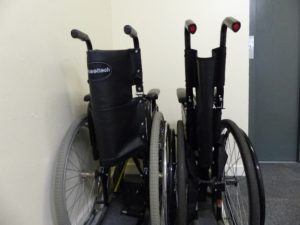 Image of 2 spare wheelchairs next to a lift,
