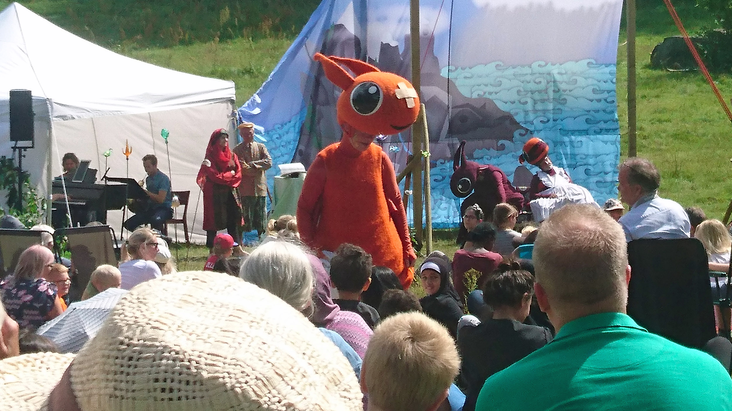 Draken Kjetil går ut och sjunger bland barnen i publiken.