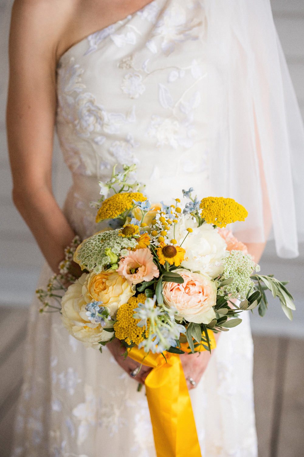 En vacker bröllopbukett i ljuva toner av gult skapad av floristerna på Bara Blommor i Malmö. Brudklänningen kommer från ERDEM i London. Foto: Tove Lundquist som arbetar som bröllopsfotograf i Skåne.