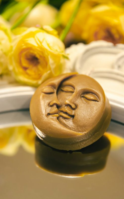 Close-up, decorative candle in the shape of the sun and moon.