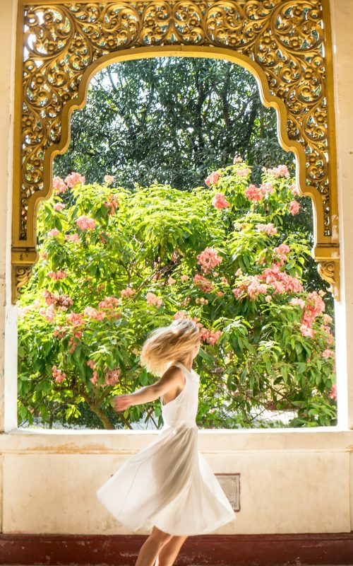 Woman spinning in a dress in the beautiful secret garden