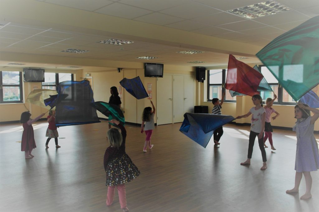 Indoor group during children's worship using flags.