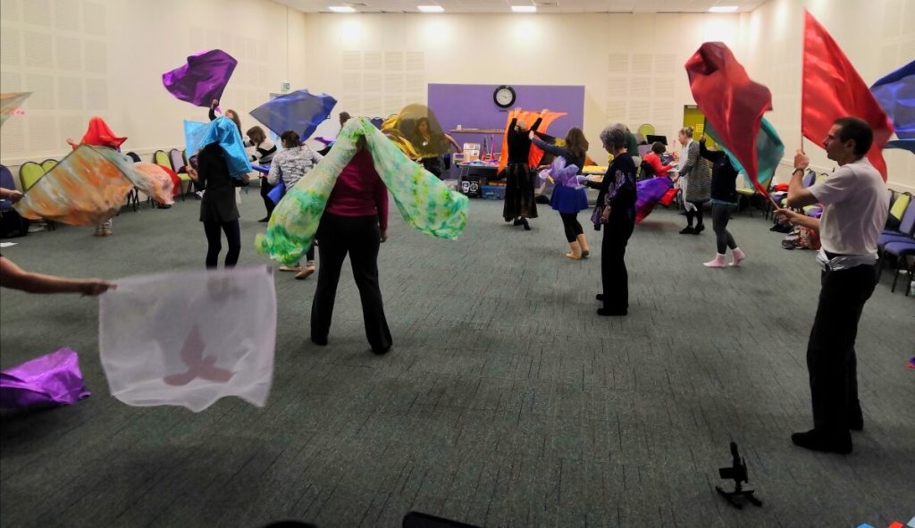 Group of worship dancers moving with worship flags.