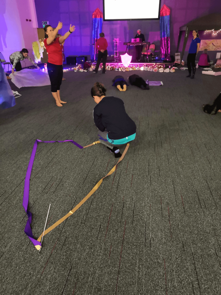 Heart shape on floor with ribbons. Person praying.