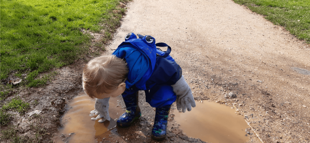 Child exploring puddles