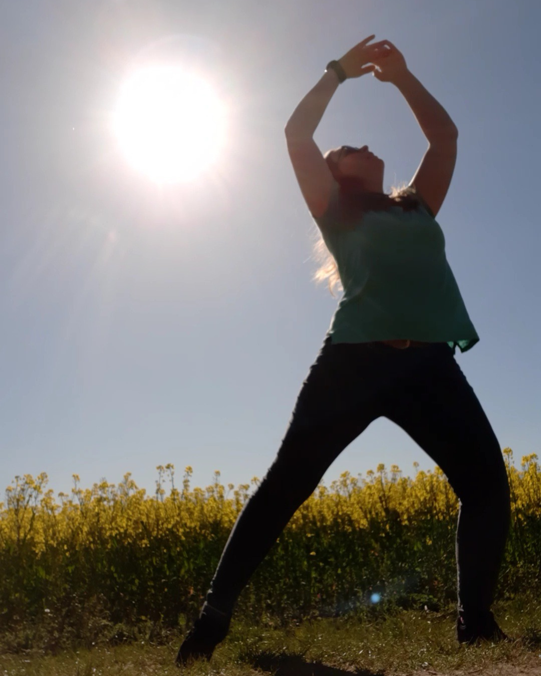Moving in the sun Sun shines brightly with dancing raising hands above head in circle.