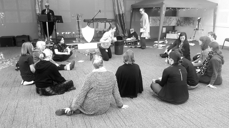 Movement prayers in a small group. Arms raised in V with others making contact with hands.