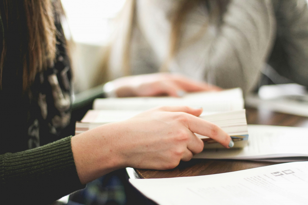 En student som leser i en bok for å illustrere de beste studietipsene til studiestart