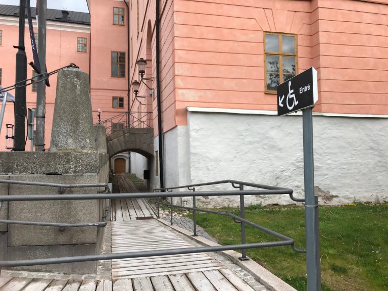 En rullstolsramp leder besökaren till en liten dörr långt bort från huvudentrén vid Uppsala konstmuseum