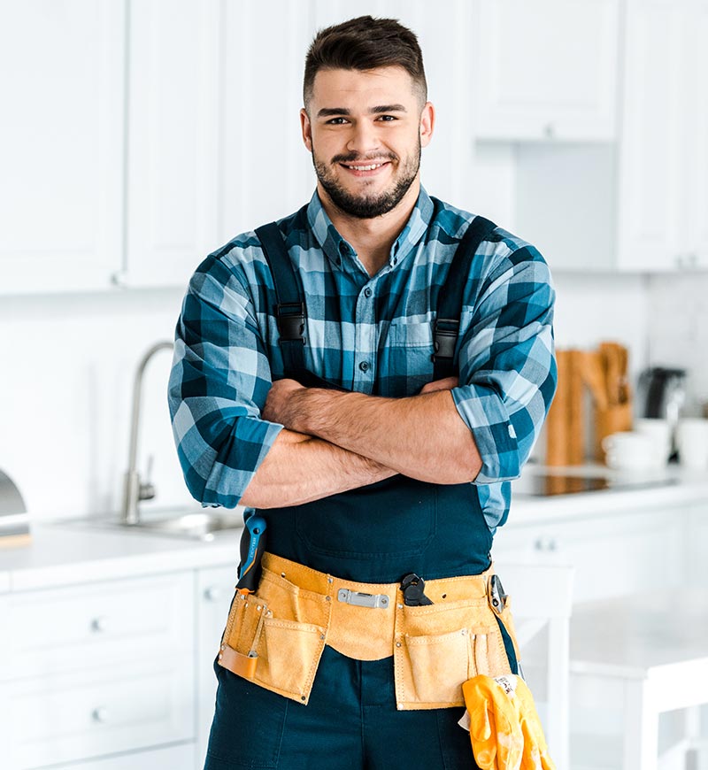 Vaktmästare står i kök med randig skjorta