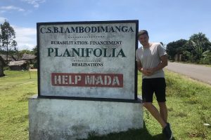 Mit besøg i Madagaskar 2022 - foran et skilt for Help Mada - som jeres vaniljekøb er med til at støtte.