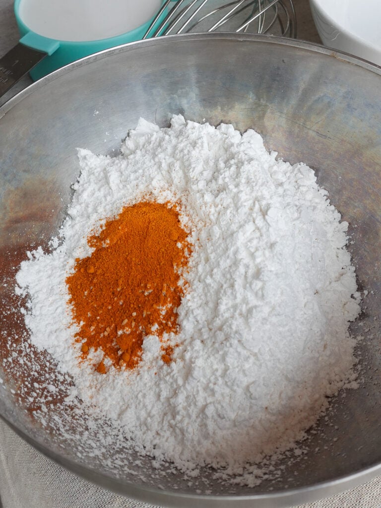 Mix together flour and turmeric powder in a bowl